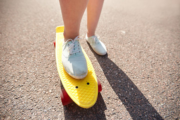 Image showing close up of female feet riding short skateboard