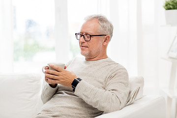 Image showing happy senior man with cup of tea at home
