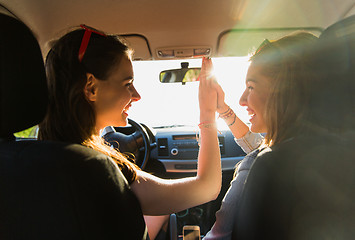 Image showing happy teenage girls or women driving in car