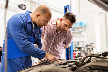 Image showing auto mechanic with clipboard and man at car shop