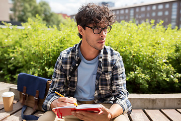 Image showing man with notebook or diary writing on city street