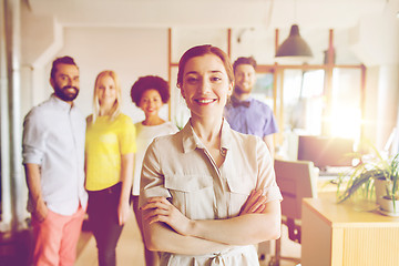 Image showing happy young woman over creative team in office