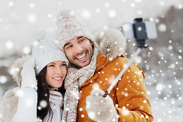 Image showing happy couple taking selfie by smartphone in winter