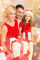 Image showing smiling family holding many gift boxes