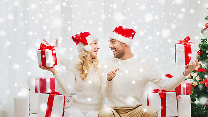 Image showing happy couple with christmas gifts and thumbs up