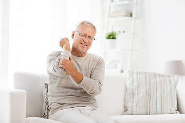 Image showing unhappy senior man suffering elbow pain at home