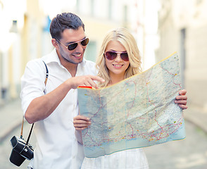 Image showing smiling couple in sunglasses with map in the city