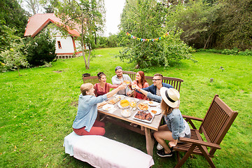 Image showing happy friends having dinner at summer garden party