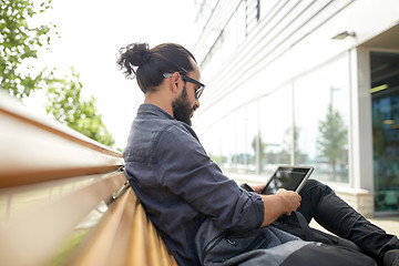 Image showing man with tablet pc sitting on city street bench