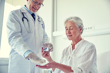 Image showing doctor giving medicine to senior woman at hospital