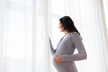 Image showing close up of happy pregnant woman looking to window