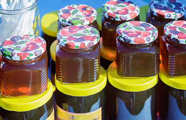 Image showing Different varieties of honey in banks, offered for sale at the f