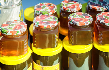 Image showing Different varieties of honey in banks, offered for sale at the f