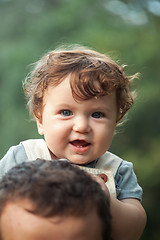 Image showing Young beautiful father and little toddler son against green trees