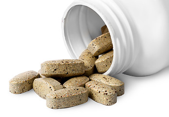 Image showing Open plastic bottle and heap of vitamins