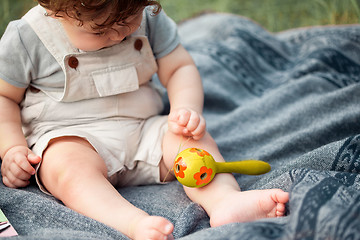 Image showing The little baby or year-old child on the grass in sunny summer day.