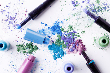 Image showing Scattered multicolored eyeshadow with brushes and tube