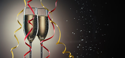 Image showing Two glasses with sparkling champagne and decorative ribbons closeup