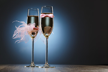 Image showing Champagne glasses with pink grooms bow-tie and brides veil