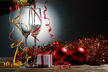 Image showing Champagne poured into glasses and Christmas decoration