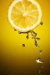 Image showing One half of lemon with fresh water drops isolated on orange background