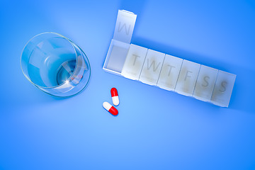 Image showing reminder box for pills and a glass of water