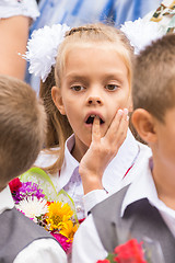 Image showing First grader on the line of the first of September thinking stuck a finger in his mouth