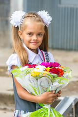 Image showing Up portrait of a seven-year school girl with a bouquet of flowers