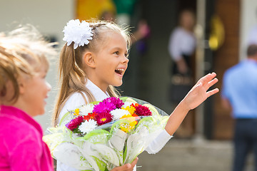 Image showing First-grader at the school the first of September in greeting waving his girlfriend