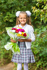 Image showing First grader with a bouquet of flowers smiling happily