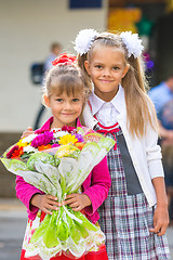 Image showing Portrait of two girls in school September 1 - the first-grader and her younger sister with a bouquet in hands