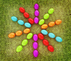 Image showing Colored Easter eggs as a flower on a green grass. 3D illustratio