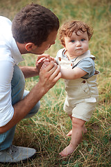 Image showing Young beautiful father and little toddler son against green grass