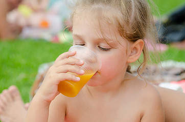 Image showing Girl drinking fruit juice from a plastic disposable cup