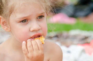 Image showing Girl eating cookies and drinking juice from a plastic disposable cup