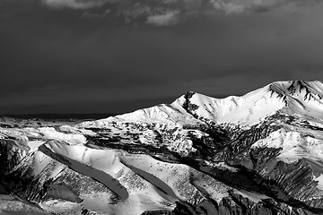 Image showing Black and white winter mountains at sun evening and dark clouds