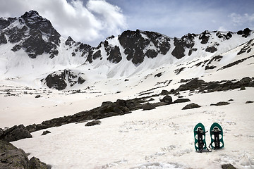 Image showing Snowshoes in snow mountains in sun spring day