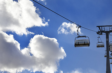 Image showing Chair-lift and blue sky with sunlight clouds