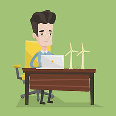 Image showing Man working with model wind turbines on the table.