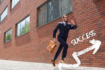 Image showing young businessman running in a city street