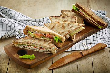 Image showing various triangle sandwiches on wooden board