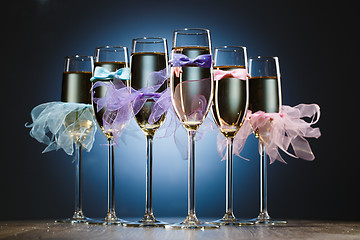 Image showing Set of glasses with champagne in colored dress newlyweds