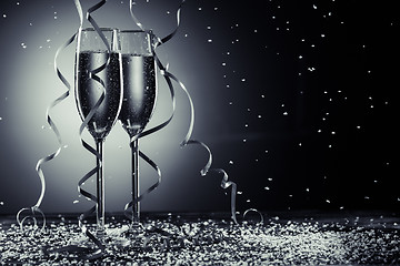Image showing Stylish image of champagne glasses on dark background with snowfall