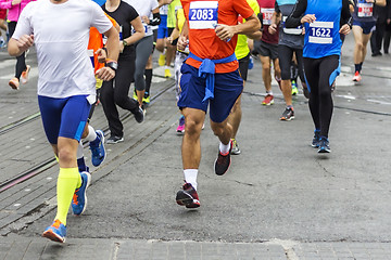 Image showing Marathon runners race in city streets, blurred motion