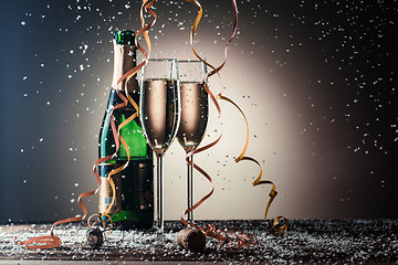 Image showing Glasses of champagne, green bottle and snow flakes