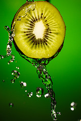 Image showing Kiwi in water splash, isolated on green background