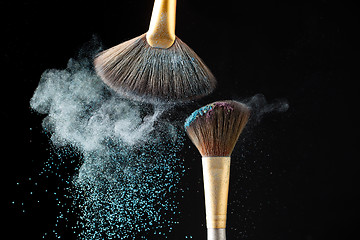 Image showing Thick professional brush and loose powder particles scattered around