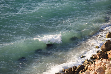 Image showing Scenic shoreline with large boulders and clear turquoise sea waves