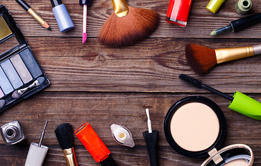 Image showing Makeup cosmetics, brushes and other essentials on brown background