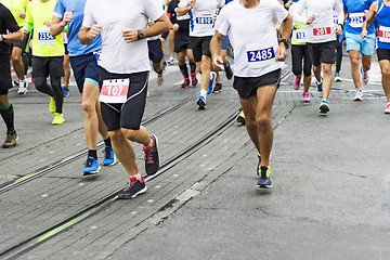 Image showing Marathon runners race in city streets, blurred motion